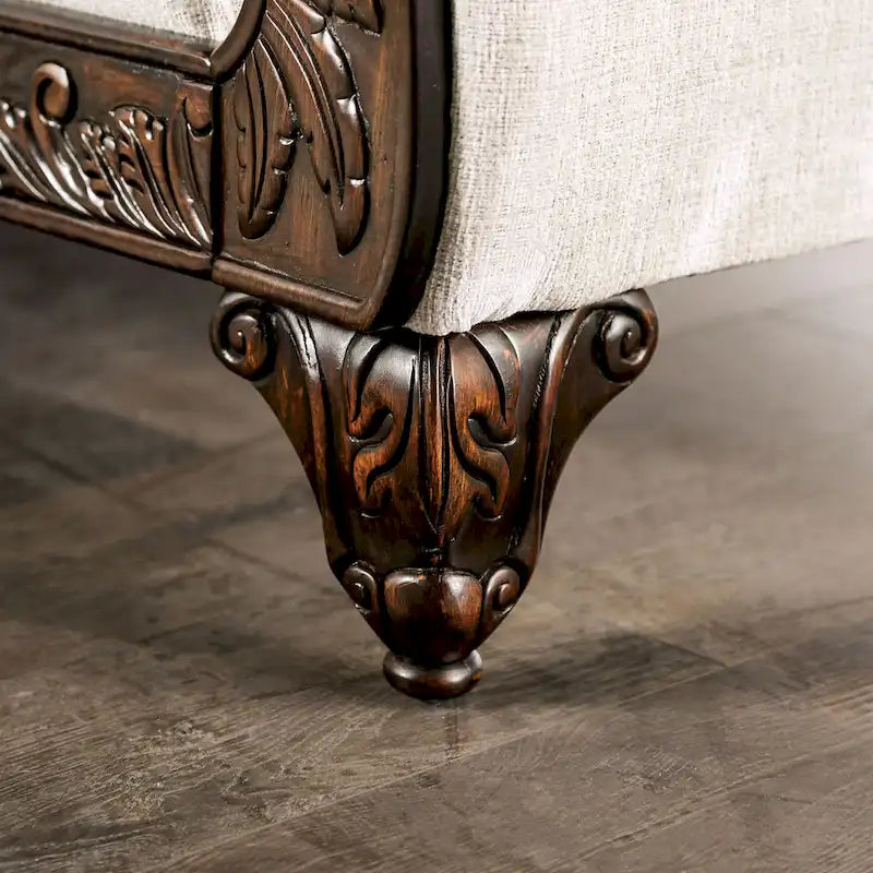 Canapé en chenille gris clair de style traditionnel avec accoudoirs enroulés et détails capitonnés.